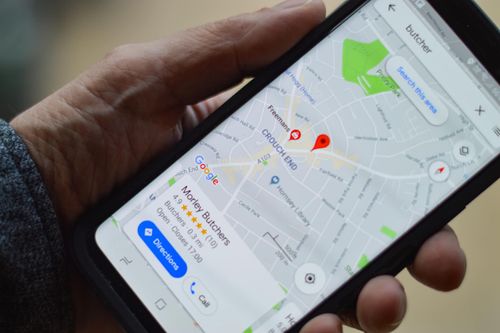 Hand hält ein Smartphone mit Google Maps